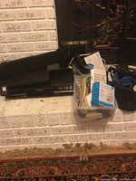 Photo showing Panasonic DVD recorder, Lenovo ThinkPad laptop, black sound bar, clear plastic bins with carbon monoxide alarms and various cords.