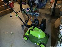 Sun Joe electric lawn mower front and side view showing green body and wheels, handle folded upright.