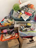 Overall view of various paint supplies, cleaning brushes, and accessories packed in plastic trays and baskets.