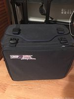 Front view of closed black Crop In Style rolling craft case with logo