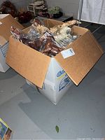 Cardboard box filled with individually bagged model horses and newspaper packing