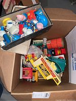 Cardboard box with assorted Fisher-Price Little People playsets and tea set pieces