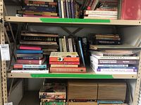 Wide view of multiple shelves filled with an assortment of books focused on yoga, music, health, and wellness including fiction and children's books.