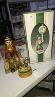 Three Emmett Kelly collectibles: table clock, ceramic music box, Coca Cola music box with box