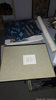 Table overview showing The Audubon Folio, Andrew Wyeth Four Seasons folio, and rolled tall ship print.