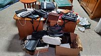 First photo showing a range of purses, wallets, and clutches in various colors and styles including box and wicker containers for storage.