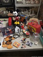 Full view of assortment of vintage Mickey Mouse toys, collectibles and memorabilia on table