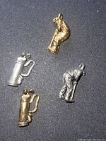 Four golf-themed charms displayed on black background, showing two gold plated and two pewter finish pieces including golfer figures and golf bags.