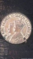Close-up front view of a silver-tone souvenir coin pin featuring King George VI and Queen Elizabeth profiles with text "KING GEORGE VI - QUEEN ELIZABETH" around edges.