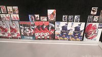 Photo showing arranged hockey cards and memorabilia featuring Patrick Roy, Wendel Clark, Eric Lindros, and Sergei Federov in multiple groups against a black background.