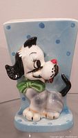 Front-side angled view of vintage Lefton dog planter showing detailed dog figure and blue polka dot background