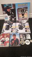Full view of all magazines, hockey cards, and memorabilia tokens arranged on floor, featuring Wayne Gretzky themes and images.