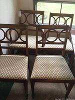 Front view of all six chairs clustered together showing backrest design and patterned seats