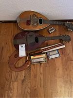 Overview of two mandolins, four boxed harmonicas, recorder, harp, and pitch pipe