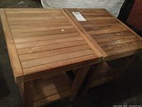 Two matching teak wood side tables shown side by side, highlighting worn surfaces and weathered wood with some stains and scratches.
