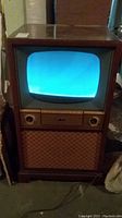 Vintage RCA Victor TV with wooden cabinet showing blue screen powered on