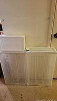 Two large clear plastic under-bed storage containers with lids stacked side by side, shown from front to display size and lid detail.