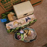 Photo of handpainted decorative box, rectangular butterfly plate, pig figurine, miniature floral figurine, seashell-shaped item, and two irregular ceramic plates