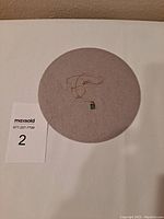Pendant and chain displayed on round gray pad with lot card