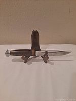 Side view of the Kabar 1207 utility knife on display stand, showing blade and handle details.