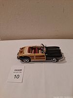 Side view of the die-cast model car showing body details, wood paneling, and convertible top.