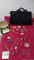 Full view of purse and all jewelry items arranged on red cloth