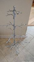 Full view of the silver metal jewelry display tree showing its height and branches.