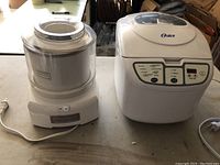Photo showing Oster bread maker (model 5838) and Cuisinart ice cream and yogurt maker side by side on a table.