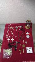 Full lot on red cloth with rosaries, crucifixes, medallions, trinket box and figurine displayed