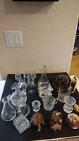 Wide view of entire lot arranged on table showing glassware and figurines, providing overall context.