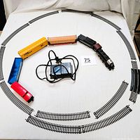 Full train set with locomotive, 5 cars, control transformer, and track pieces arranged on table.