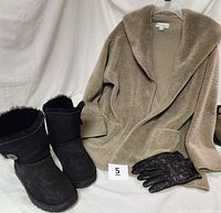Koolaburra tan plush cardigan jacket on hanger with black UGG boots and black leather gloves on white background