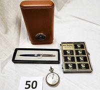 Full lot showing four main items: leather case, pen in box, plastic case with matchboxes, and antique pocket watch.