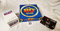 Photo showing three game boxes: What Do You Meme?, Exploding Kittens, and The 80s Game