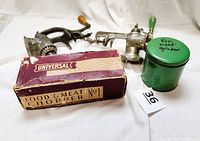 Photo showing two vintage metal food and meat grinders with clamps, original box labeled Universal Food & Meat Chopper No. 1, and green metal container marked for meat grinder.