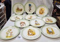 Eleven vintage Holly Hobbie porcelain collectible plates displayed with inspirational sayings and illustrations, showing full set and detail.