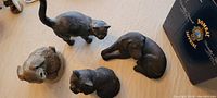 Top view photo showing all three animal lawn ornaments placed on floor: two black cats and one gray rabbit.