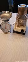 Photo of Cuisinart food processor and vintage dial kitchen scale side by side on table