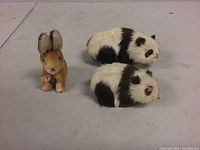 Overall photo of all three items on a flat surface showing the Steiff Sonny rabbit and two smaller pandas.