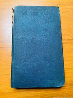 Front cover of the hardcover book showing the textured dark cover with wear at the corners and spine.