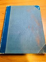 Front cover of Dominion Illustrated 1890 book showing heavy wear, blue cloth spine and corners with grey cloth covers.