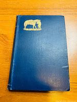 Front cover of 1892 hardcover book with blue textured cover and gold-embossed horse and rider image.