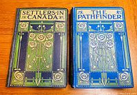 Front covers of two hardcover books: 'Settlers in Canada' with dark blue and green decorative cover and 'The Pathfinder' with blue and green decorative cover.