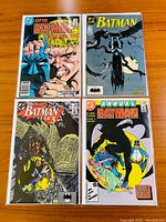 Four Batman comic books laid out on a wooden surface, showing covers of issues #403, #431, #439, and Annual #11.