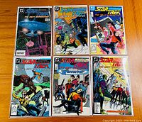 Photo of all six Star Trek The Next Generation comics in the lot, showing front covers featuring a mix of space and character action scenes.