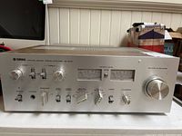 Front view of amplifier showing silver faceplate, meters, knobs and switches