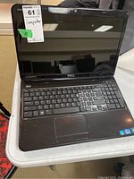 Full view of the laptop showing the keyboard, screen, and touchpad, on a table surface.