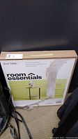 Photo of the original packaging for a Room Essentials End Table, showing the product image and brand.