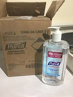 Four Purell Advanced Hand Sanitizer 1L pump bottles inside an open cardboard box labeled Gojo 3080-04-CMR.