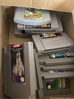 Overview of nine grey NES cartridges stacked in a cardboard box